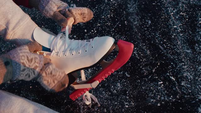 溜冰前戴着连指手套系溜冰鞋的女人视频素材