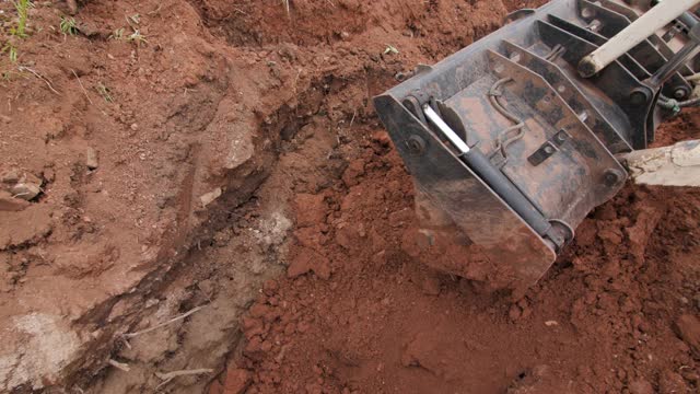 挖掘机用用套管覆盖的管道在地面上埋沟视频下载