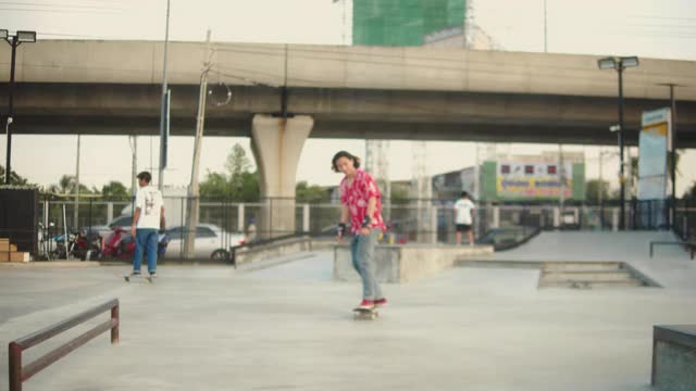 亚洲朋友一起在公园玩滑板。视频下载