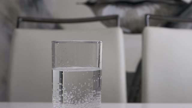 43、矿泉水在玻璃杯里，倒一玻璃杯水，水流出矿泉水，喝水。视频素材