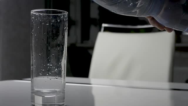 43、矿泉水在玻璃杯里，倒一玻璃杯水，水流出矿泉水，喝水。视频素材