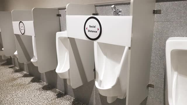 男用公厕的小便池有社交距离标志。视频下载