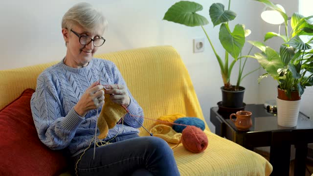 一位退休妇女在客厅里编织苍蝇拍视频下载