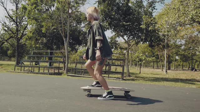 十几岁的女孩在一个阳光灿烂的日子里玩滑板。视频下载