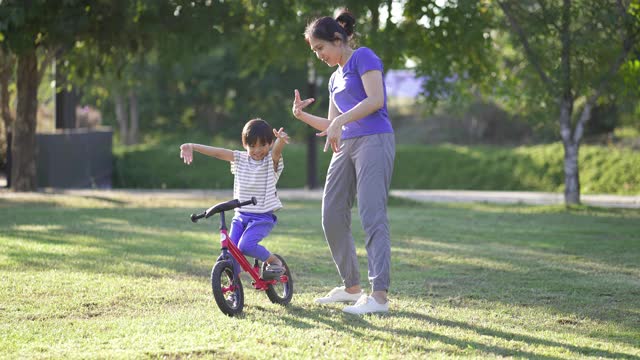 亚洲母亲和儿子一起跳舞在公园，户外。视频素材