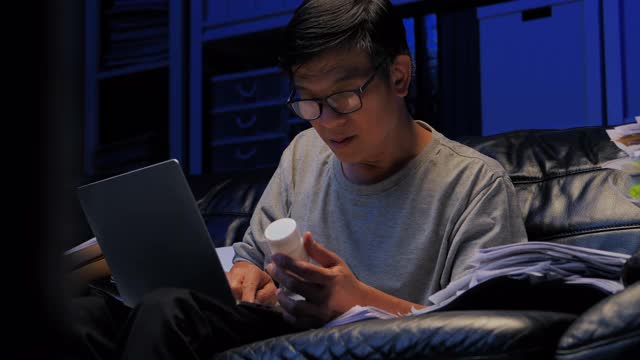 57岁的亚洲老年人在工作到深夜的社交距离中使用笔记本电脑和视频会议技术通过视频会议与医疗工作者交谈。高级健康技术理念。视频素材