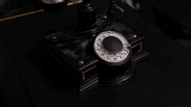 老式的黑色手机在旧木头桌子的背景。视频素材