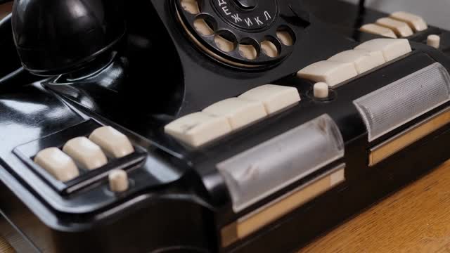 老式的黑色手机在旧木头桌子的背景。视频素材