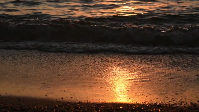 一个男人在海滩上散步，大海是他的背景。视频素材