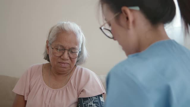 女医生为一位老年病人检查血压。视频素材