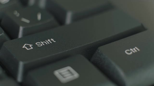 手指反复按下黑色键盘上的shift键。视频素材