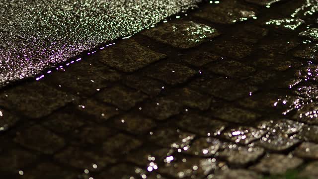 在雨天的夜晚，行人走过水坑视频下载