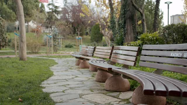 在冠状病毒时代，公园里的木制长椅空着，人们在散步和运动以保持健康视频下载