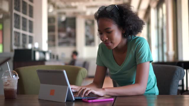 年轻的非裔美国妇女在笔记本电脑上输入电子邮件视频素材