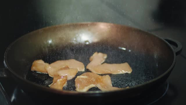 烹饪。特写镜头。肉片在平底锅里煎。烹饪视频素材
