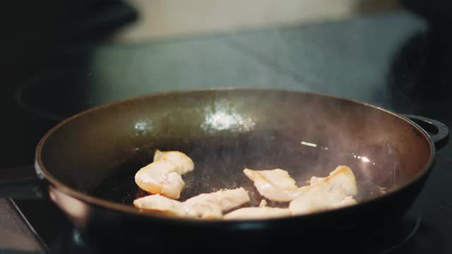 烹饪。特写镜头。肉片和蔬菜在平底锅里煎。烹饪视频素材