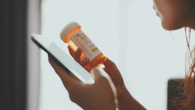 手握药瓶和使用手机的女人视频素材