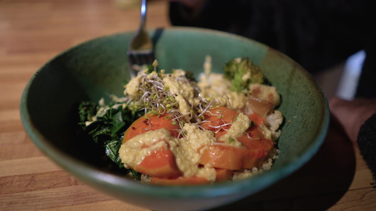 一名男子用叉子从一碗素食中挑菜视频下载