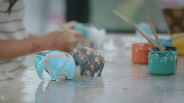 小朋友在车间里画的小陶瓷象。孩子们在学校的艺术和手工艺创意活动班。视频下载