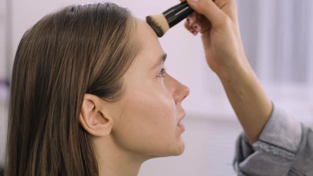 女人在美容院专业化妆由化妆师，脸部特写视频素材