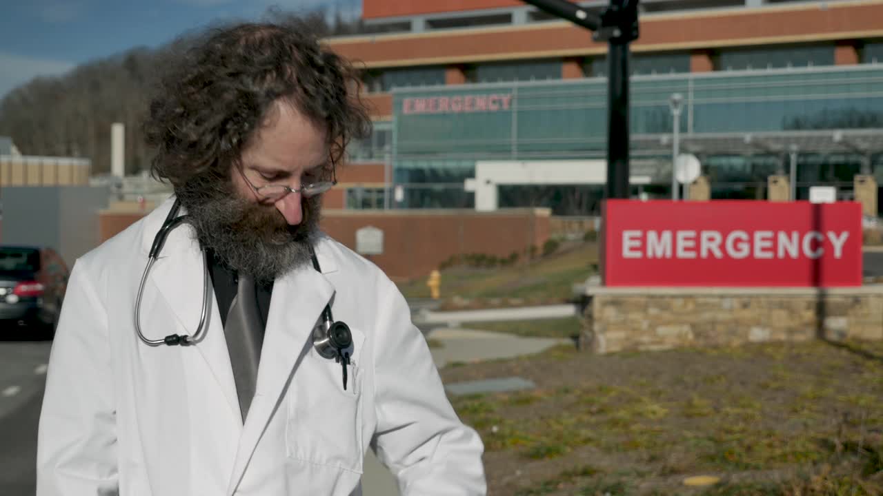 留胡子的医生戴着面具站在急救医院外面视频下载