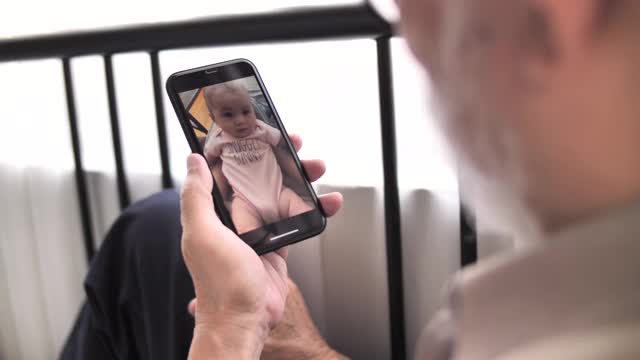 爷爷奶奶在家里用智能手机和孙子孙女视频通话视频素材