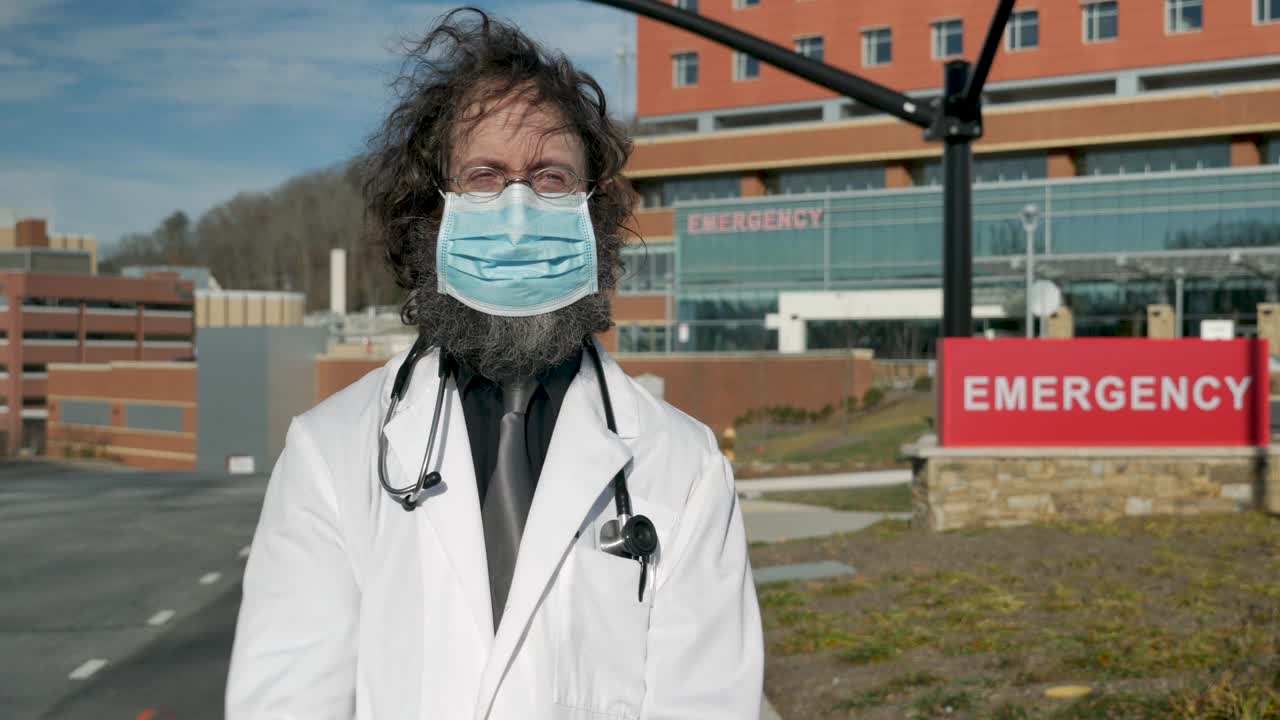 一名戴着口罩的男医生在急诊室前的肖像视频下载