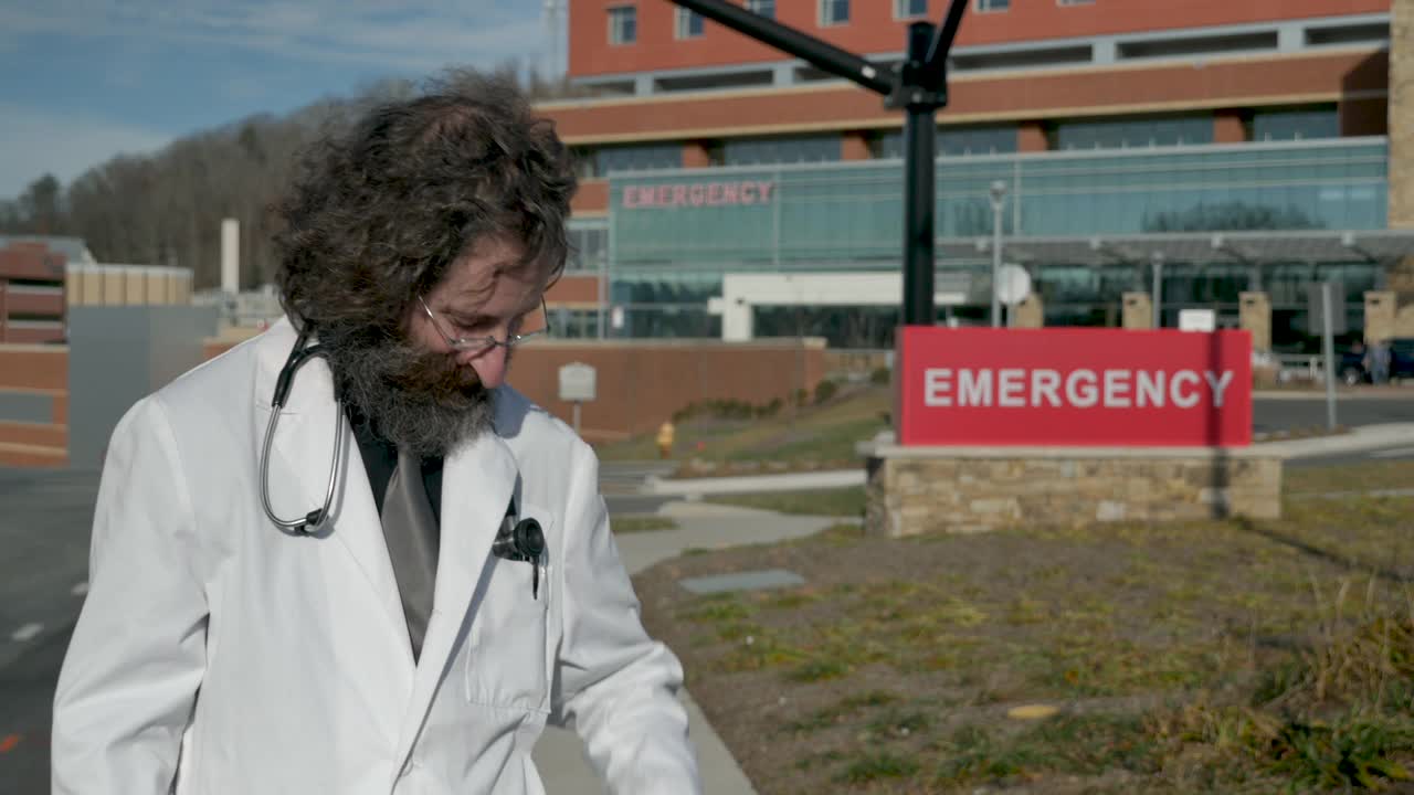戴口罩的医生在医院外肘撞人视频下载