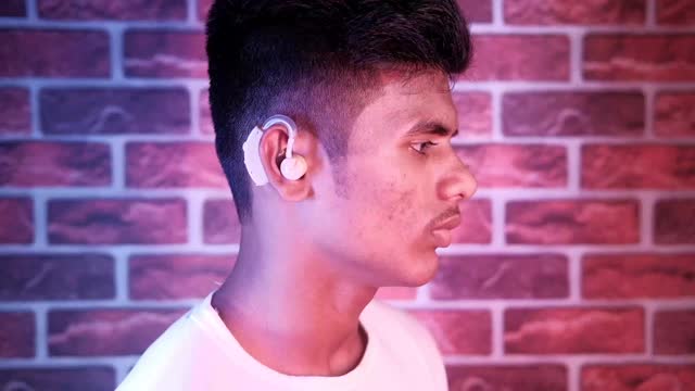 助听器概念，一个听力有问题的年轻人。视频素材