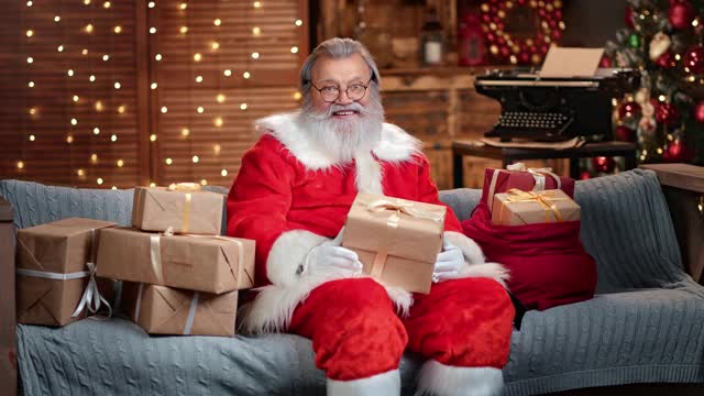 英俊的男性圣诞老人与礼物盒子在发光的花环。4k Dragon RED摄像机视频素材