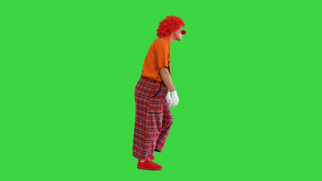悲伤不快乐的小丑在绿色屏幕上以一种有趣的方式行走，色度键视频素材
