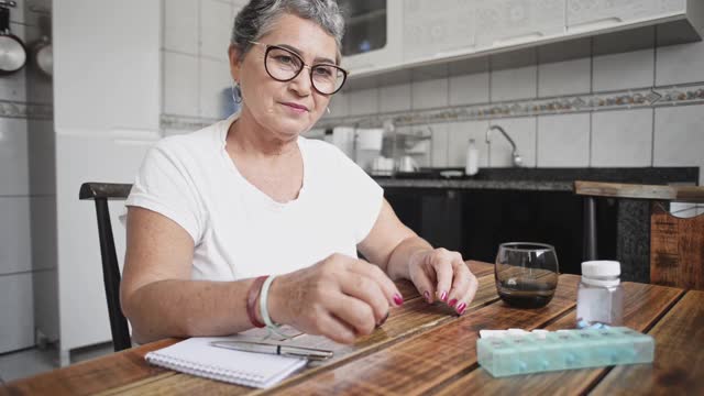 一位年长女性在家里的记事本上记录自己的血糖水平视频下载