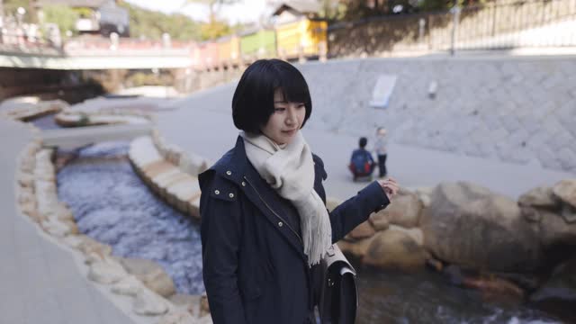 一名年轻女子在旅游地点沿河行走视频素材