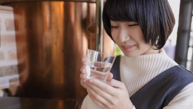 年轻女子喝日本“Saki”米酒在“Tachinomi”站酒吧- 2的第二部分视频素材