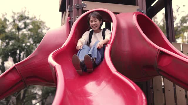 年轻的母亲和她的小女儿在公园玩滑块-第二部分视频素材