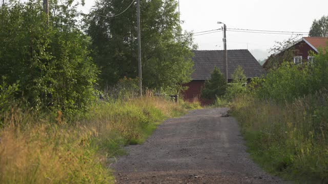 空旷的砾石路通向瑞典乡村的一些房子视频下载