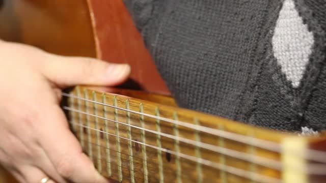 一个男人弹六弦原声吉他。扮演几个和弦。视频下载