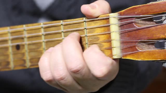 一个男人弹六弦原声吉他。和弦。吉他指板和和弦被演奏的特写镜头视频下载