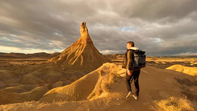 盖伊正在拍摄西班牙巴登纳皇家荒地的砂岩地层。在西班牙北部的Bardenas Reales沙漠景观中拍摄Castildetierra城堡的头部。视频素材