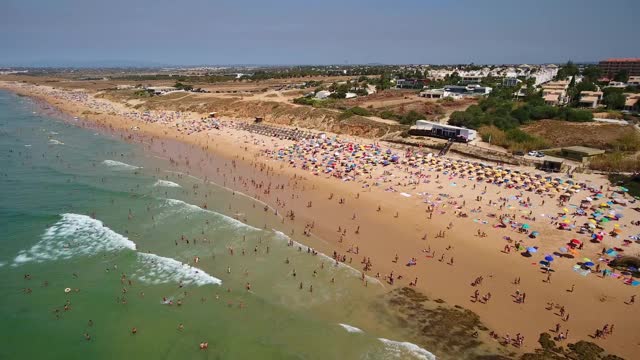 航拍葡萄牙盖尔海滩的海岸。游客们在雨伞下休息。视频素材