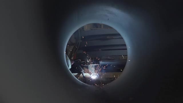 一名焊工正在通过一根大管子焊接金属摄像机角度视频下载