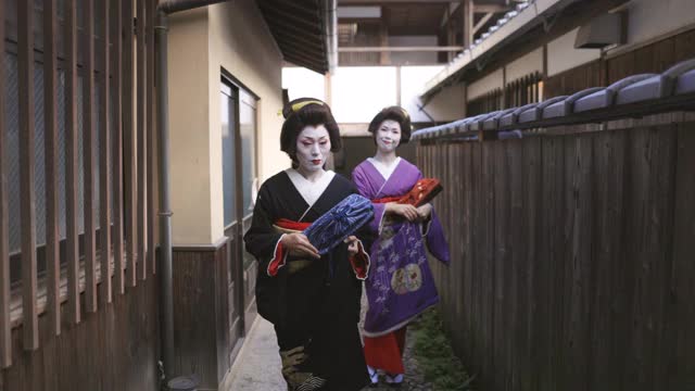 两名艺妓一起走在京都祗园狭窄的街道上视频下载