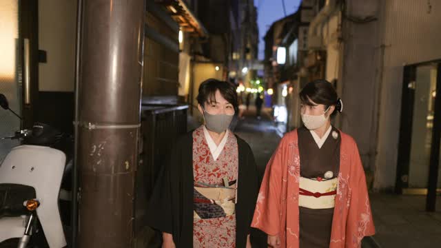 穿着和服的日本女性朋友走在京都狭窄的人行道上视频下载