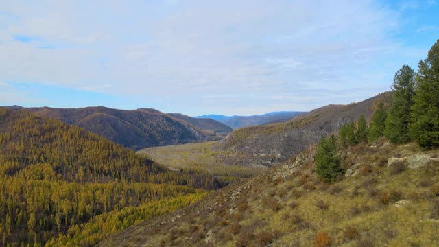 相机从左到右的跨度。多山的地形。秋天的山河在远处视频下载