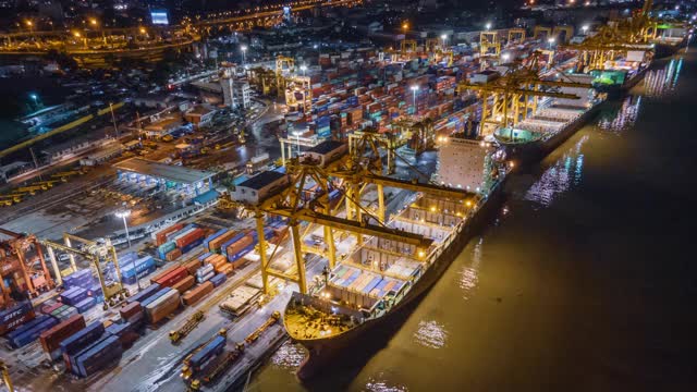 在泰国首都曼谷的船厂，使用工作吊车桥的集装箱货轮和货物的物流和运输的终端港口上空的延时坍塌视频素材