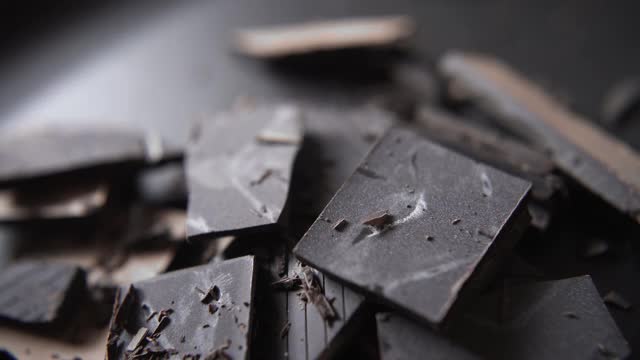 磨碎的巧克力落在黑巧克力上视频下载