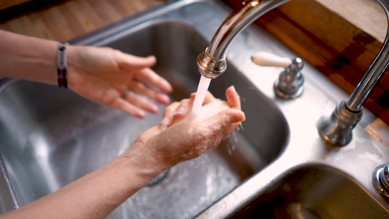一个女人在不锈钢水槽里慢镜头洗手视频下载