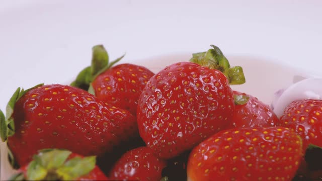 酸奶倒在有机新鲜草莓上。奶油浆果。有机素食的概念。特写,4 k分辨率。视频素材