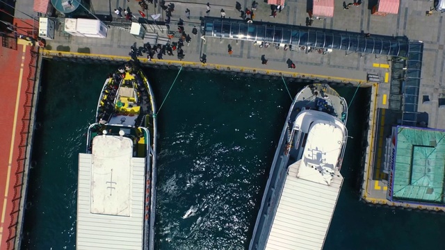 美丽的无人机拍摄鸟瞰图的人离开客轮在海港。视频下载