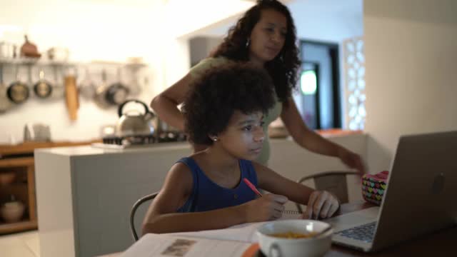 十几岁的女孩和她的母亲在家里学习视频素材